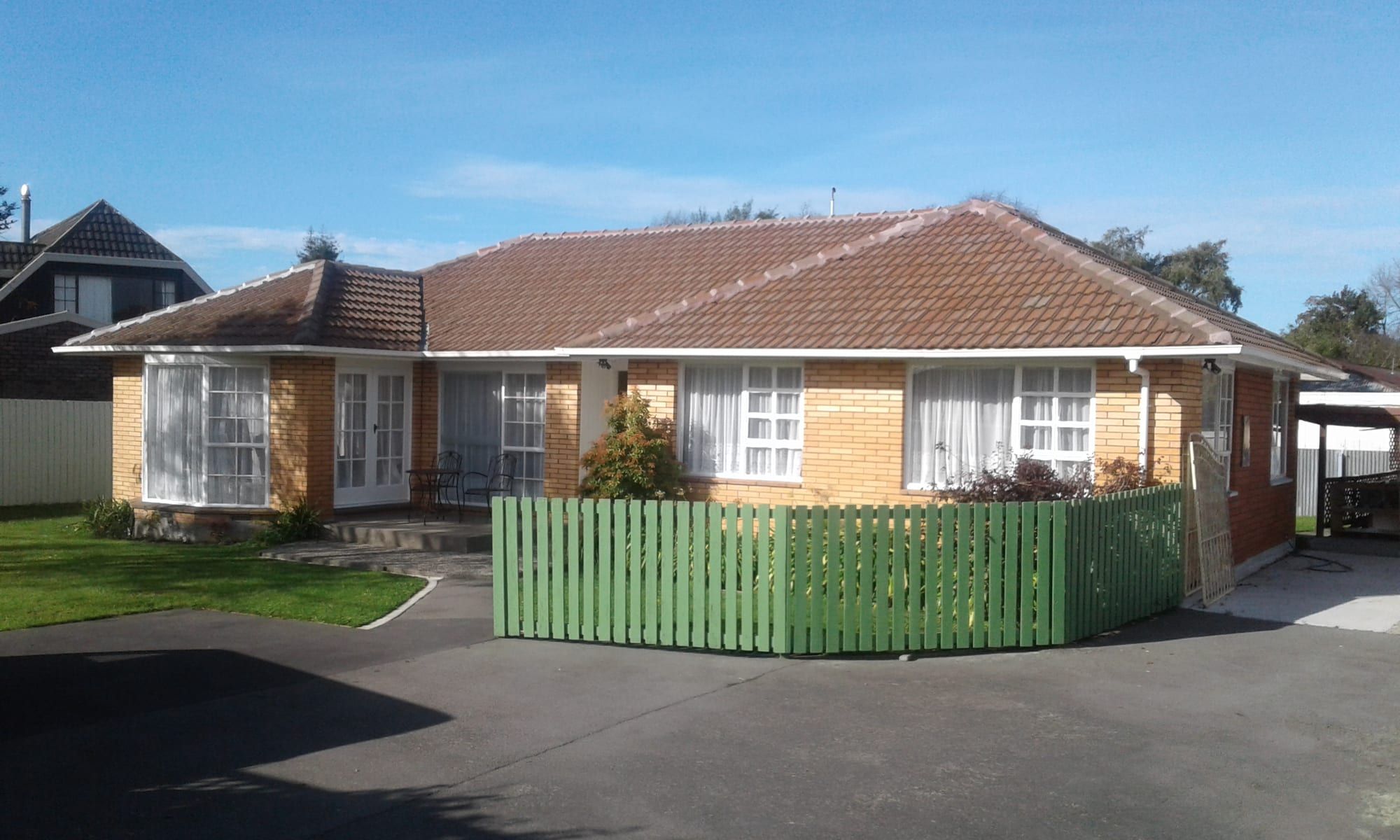 Brick and weatherboard home with a painted picket fence