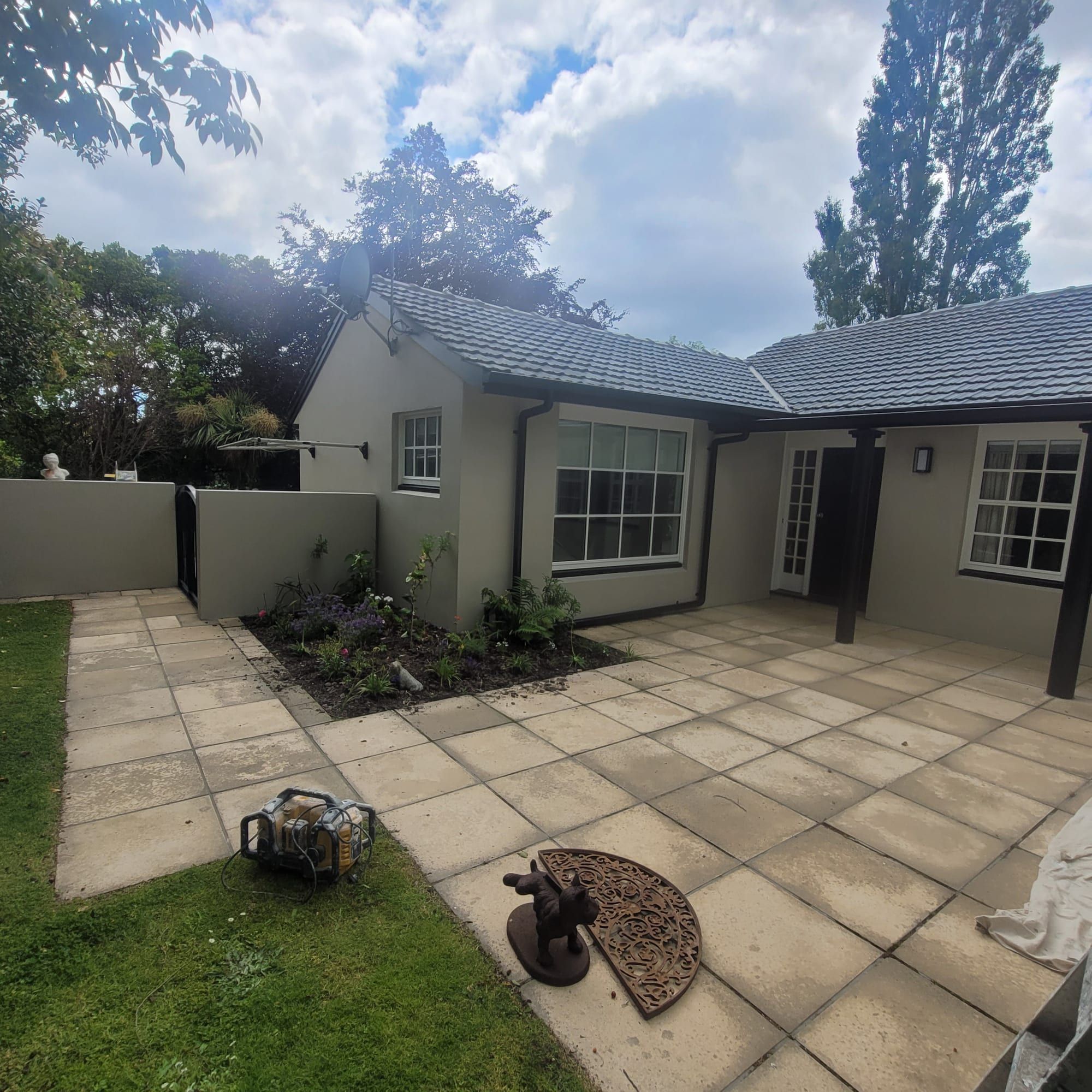 Cream exterior repaint with a tile roof and paved courtyard