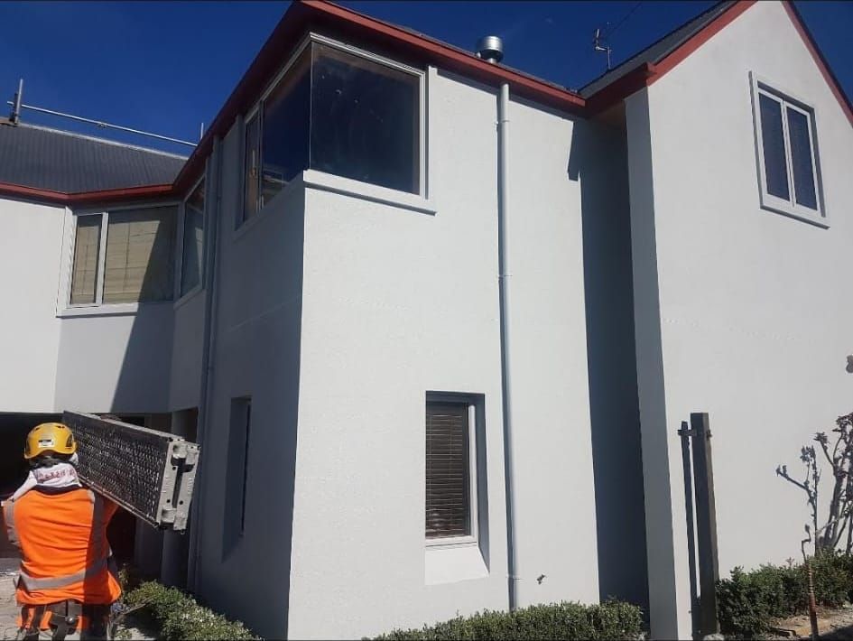 Crew on site on a white plastered exterior