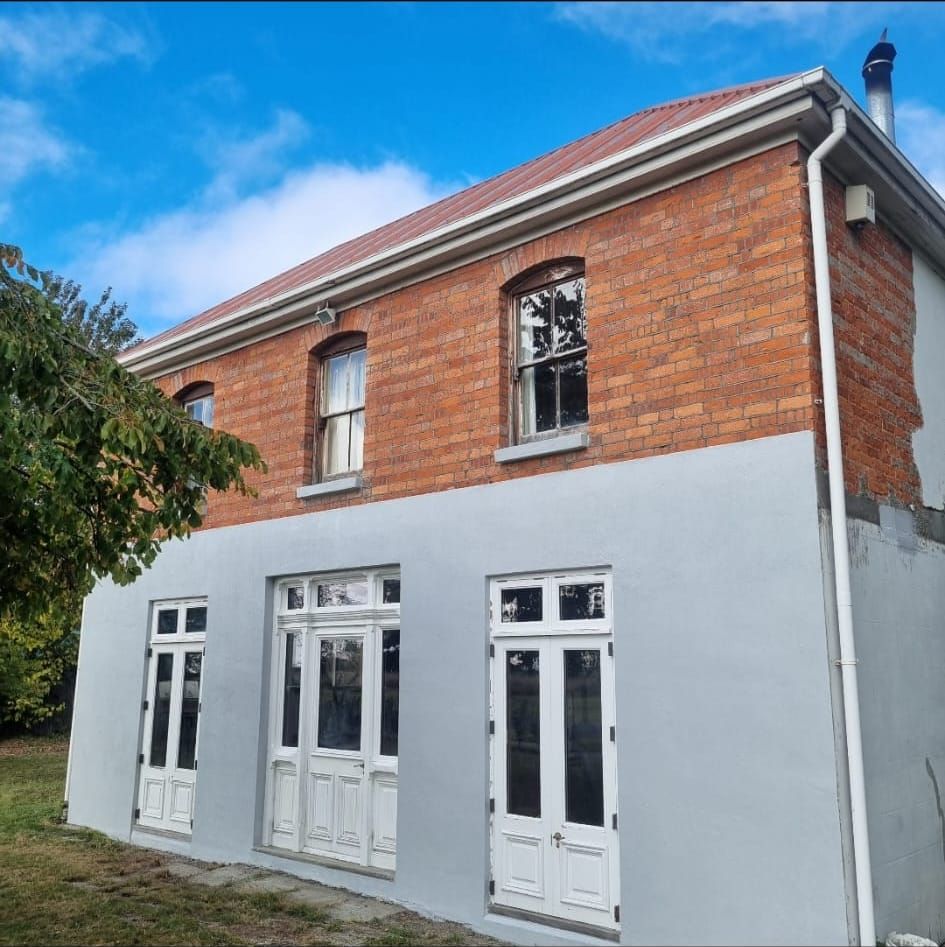 Heritage brick building with a freshly plastered base
